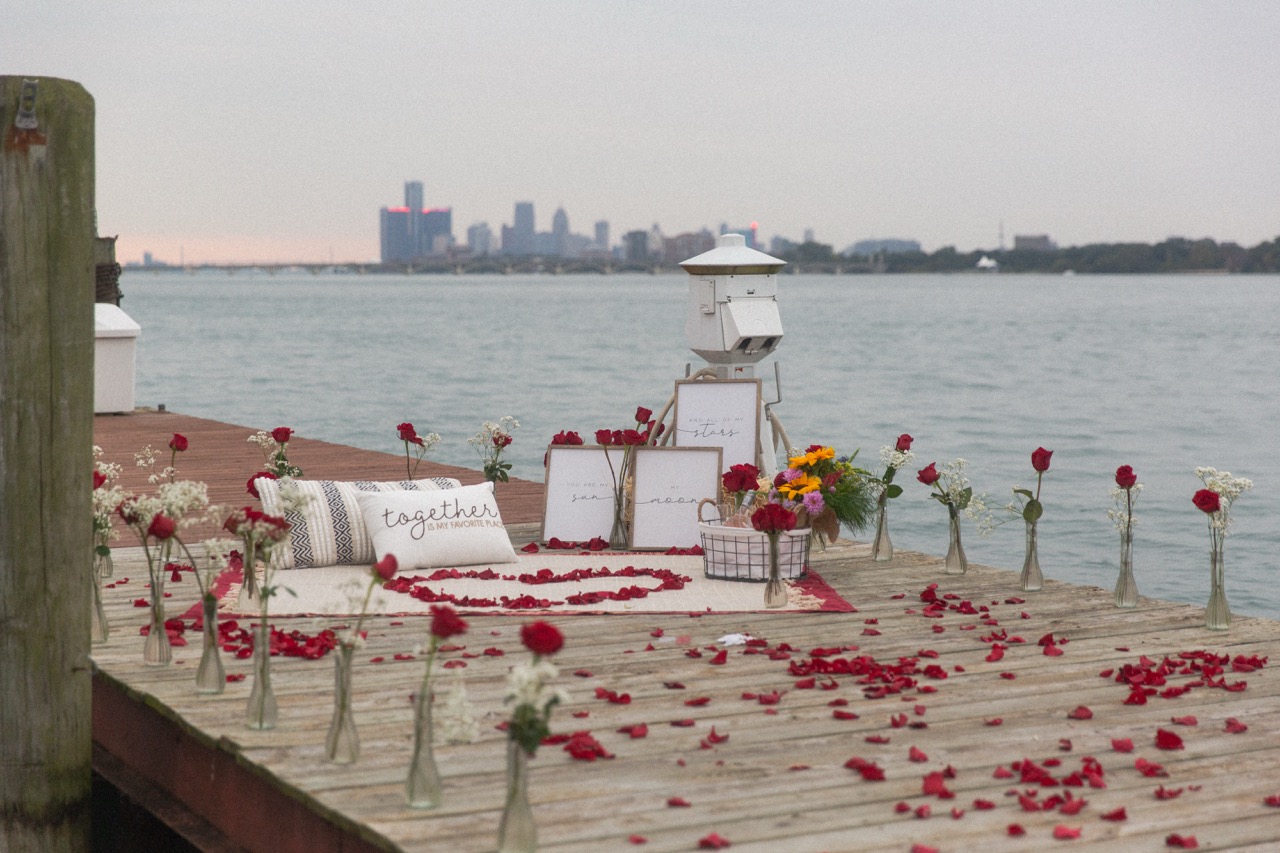 A waterfront proposal setting with roses and a city skyline
