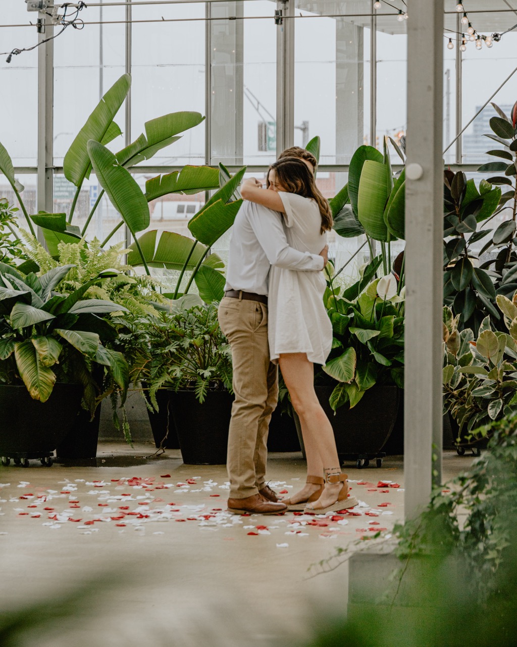 A couple embracing in a garden filled with lush greenery